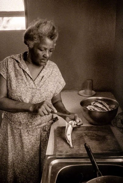 Maud Mayers prepares to cook flying fish June 1976