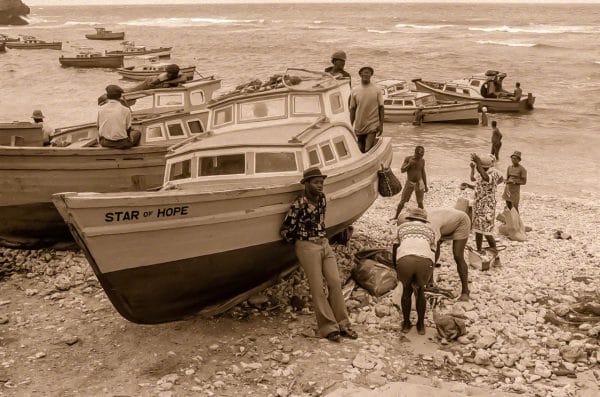 The fishermen and women of the nearby Tent Bay wait for the return of the fishing boats with their catch