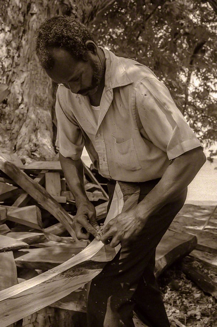 Shipwright Mr. Douglin shapes a rib
